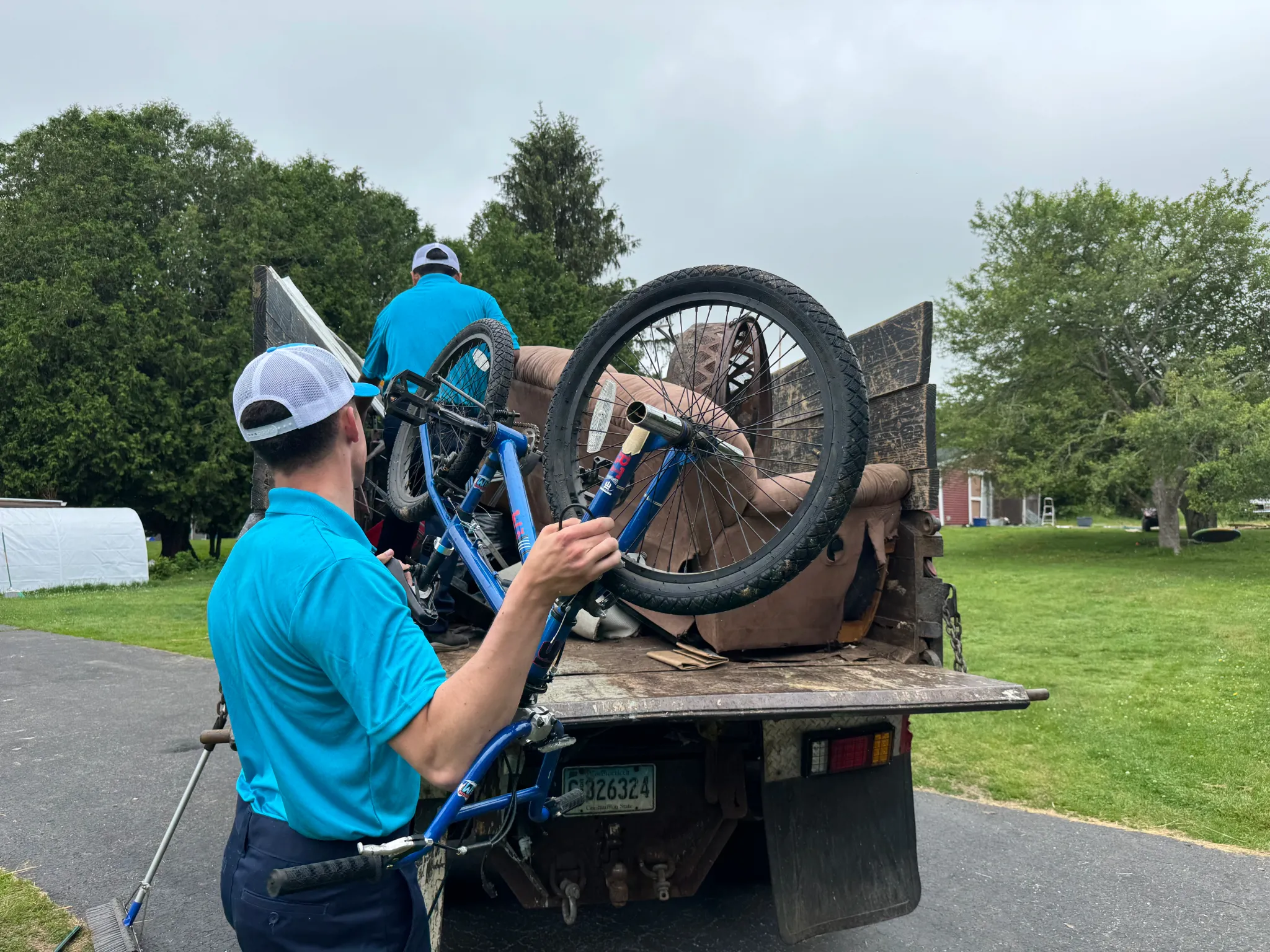 Family Cleanout Junk Removal emergency crew loading furniture and bicycles onto a truck in Eastern Connecticut