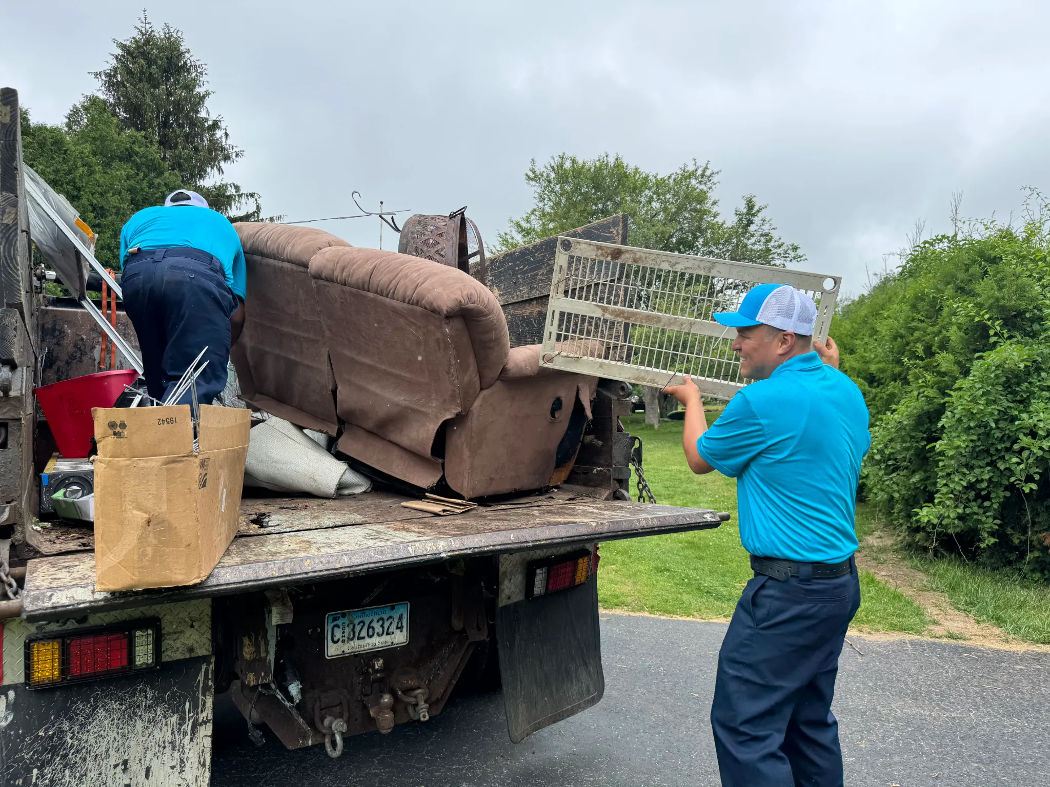 Family Cleanout Junk Removal crew loading furniture from a residential home in Norwich, CT